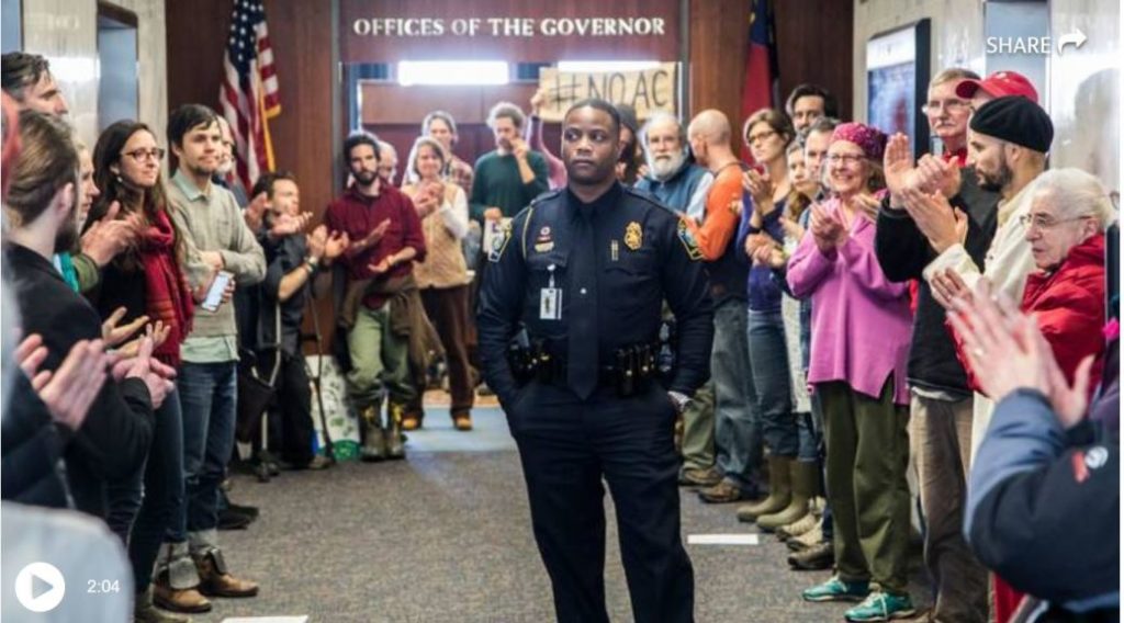 A police officer stands amid a protest outside NC Governors office